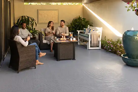 A group of friends start their day with coffee on a patio with deck tile.